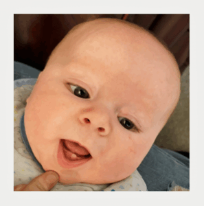 Baby showing first tooth – early sign in baby teething timeline